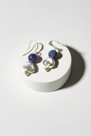 A model wearing size OneSize of the Binnie Earrings in colour Navysilv (Blue), from the front, showing the whole outfit