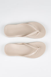 Model Genericm wearing size sample of the Islander Thong - Sand in colour Sand, in a cropped view