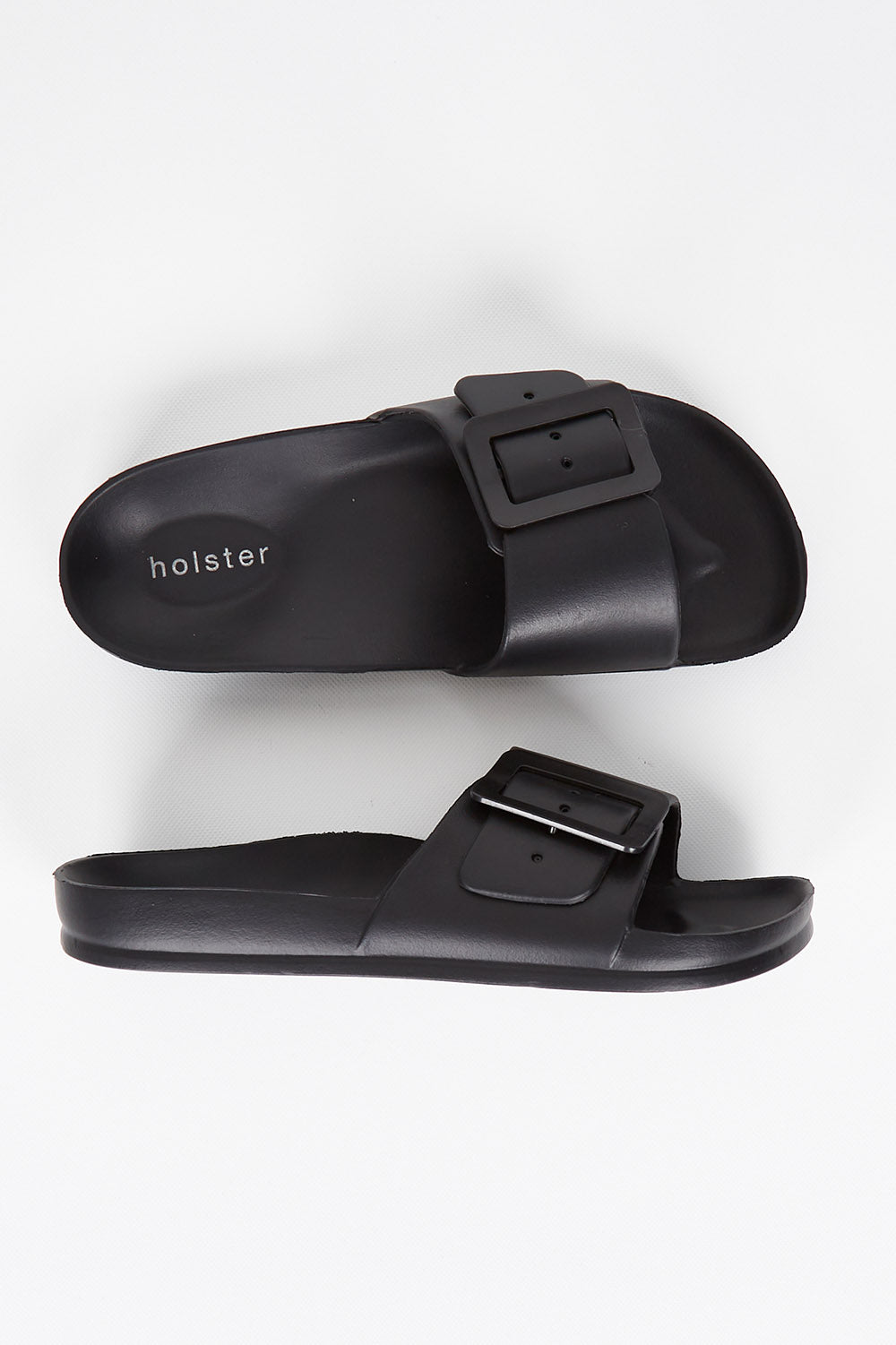 A model wearing size 7 of the Solace EVA Slide in colour Black (Black), from the front, showing the whole outfit