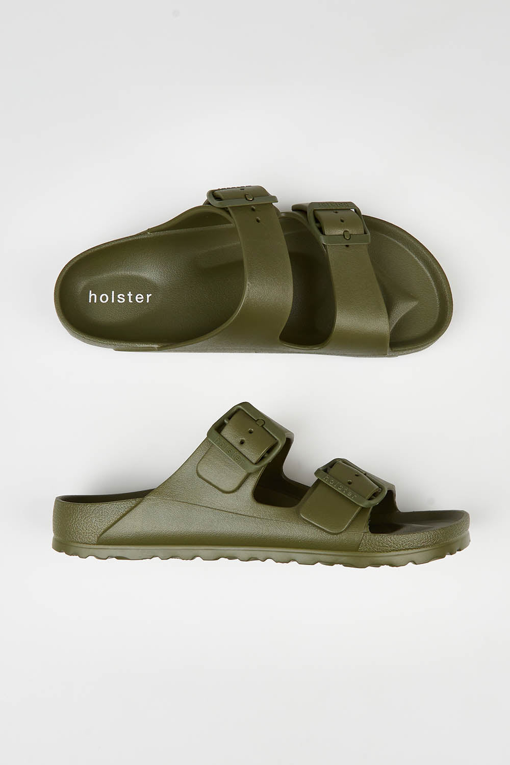 A model wearing size 7 of the Sundreamer EVA Slide in colour Khaki (Green), from the front, showing the whole outfit