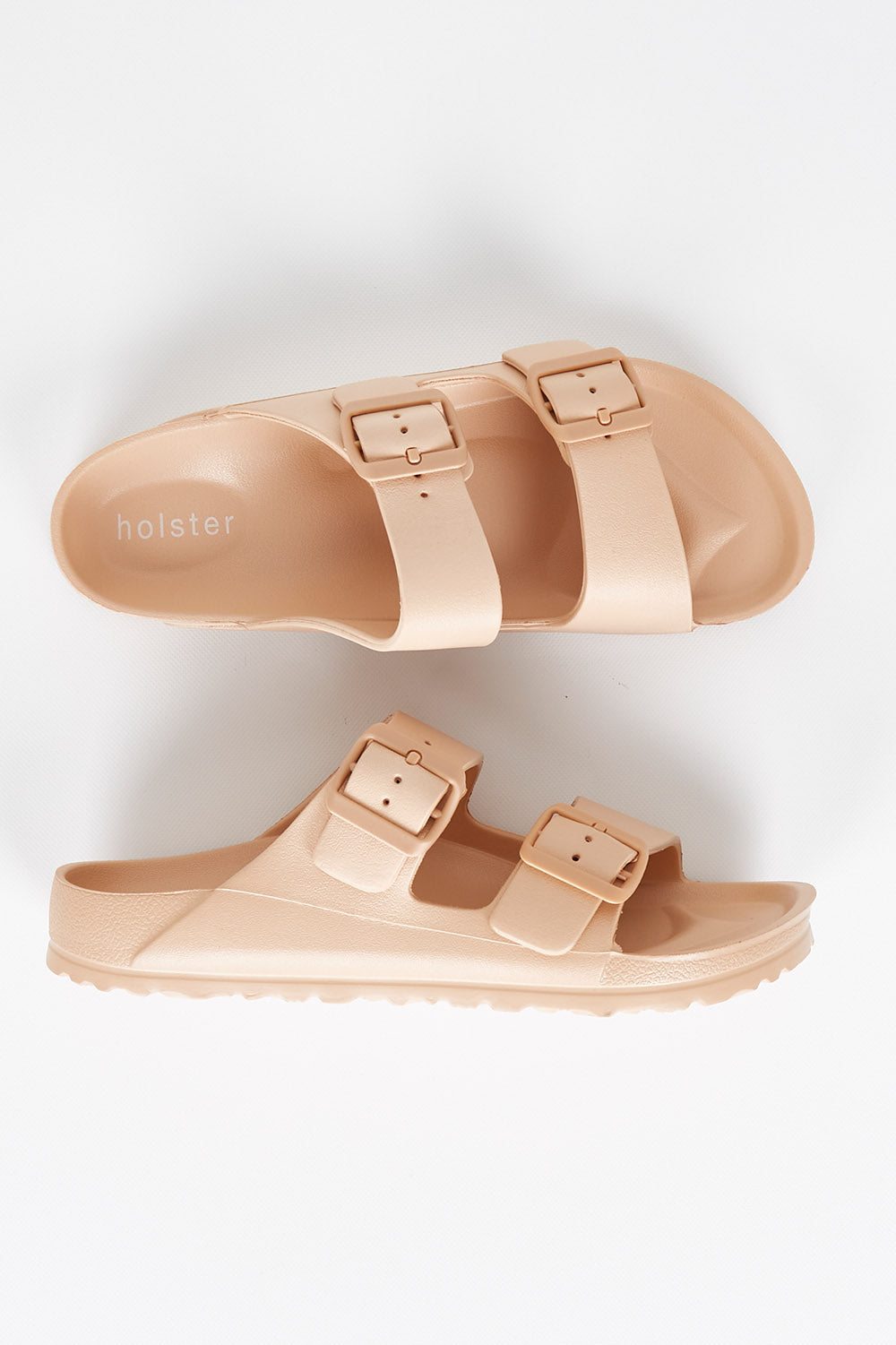 A model wearing size 7 of the Sundreamer EVA Slide in colour Tan, from the front, showing the whole outfit