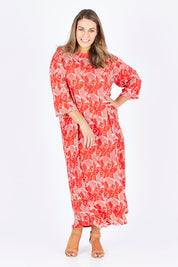 Model Natalia wearing size L of the Carabou Dress in colour NemoRed (Red), from the front, showing the whole outfit