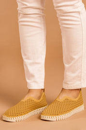A model wearing size 38 of the Tulip Sneaker in colour Goldenrod, from the front, cropped image