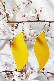 A model wearing size OneSize of the Australian Made Bold Single Leaf Leather Earring in colour Daffodil, from the front, showing the whole outfit