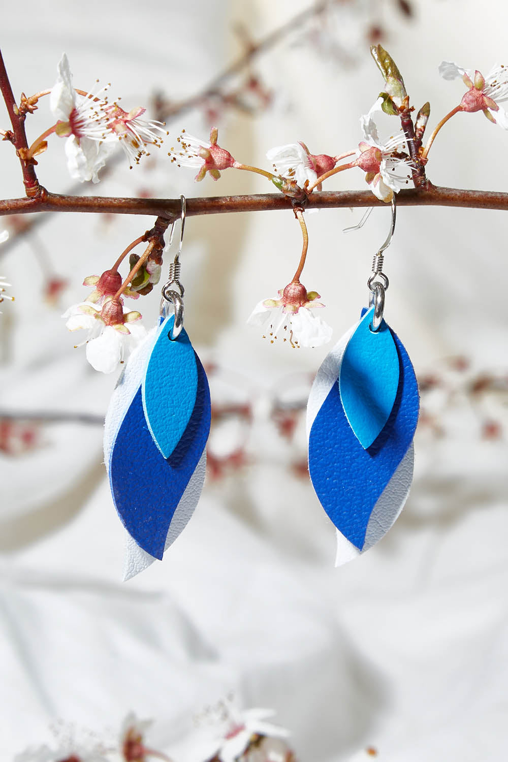 A model wearing size OneSize of the Australian Made Leather Leaf Earring in colour Bluewhite (Blue), from the front, showing the whole outfit
