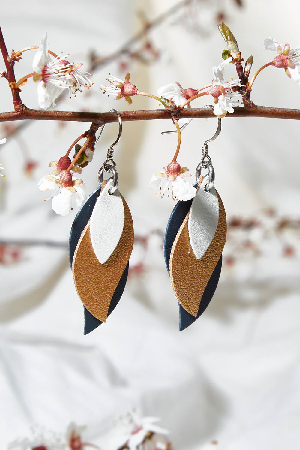 A model wearing size OneSize of the Australian Made Leather Leaf Earring in colour Ivorygold (Metallics), from the front, showing the whole outfit