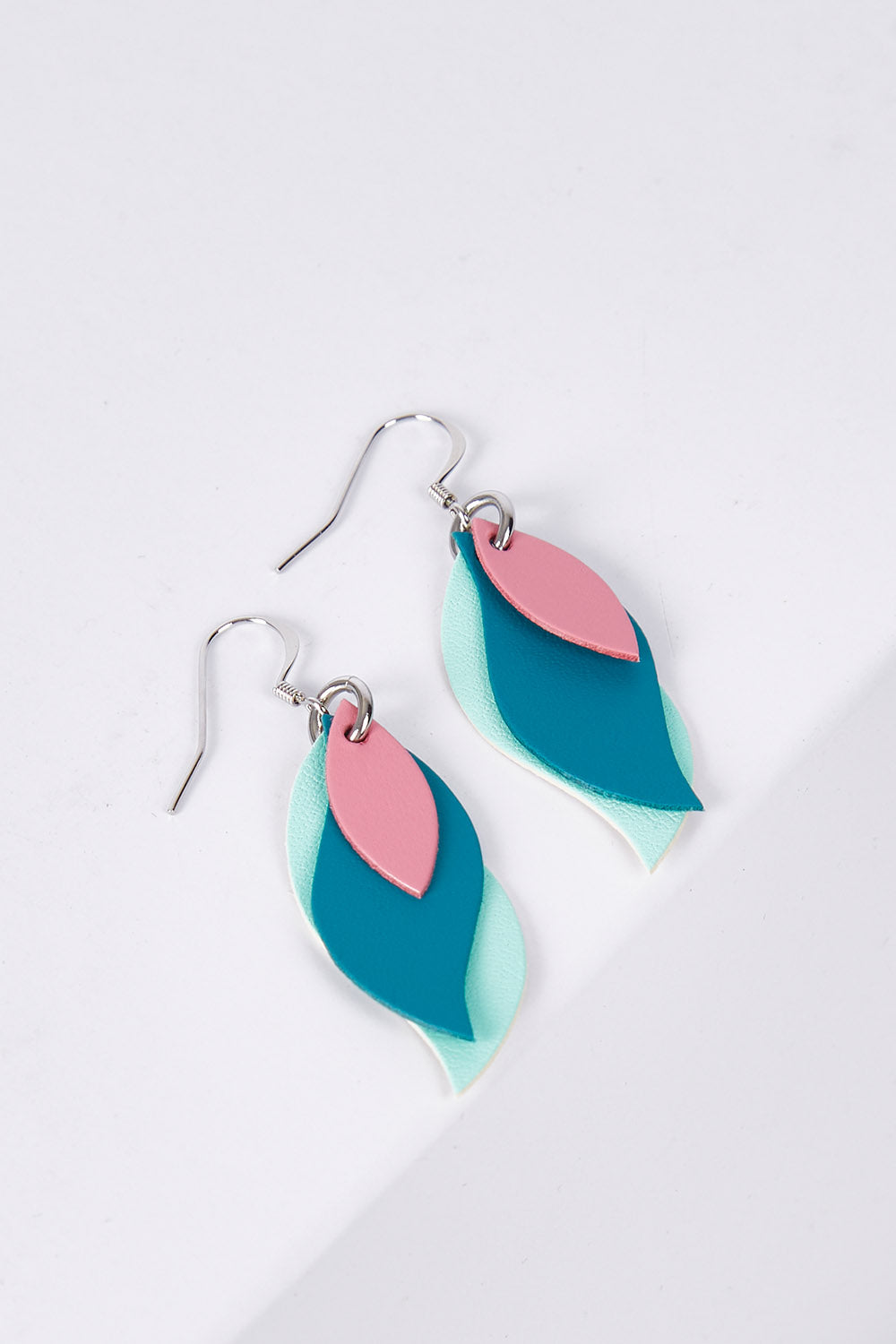 A model wearing size OneSize of the Australian Made Leather Leaf Earring in colour Pnktealmnt (Green), from the front, showing the whole outfit
