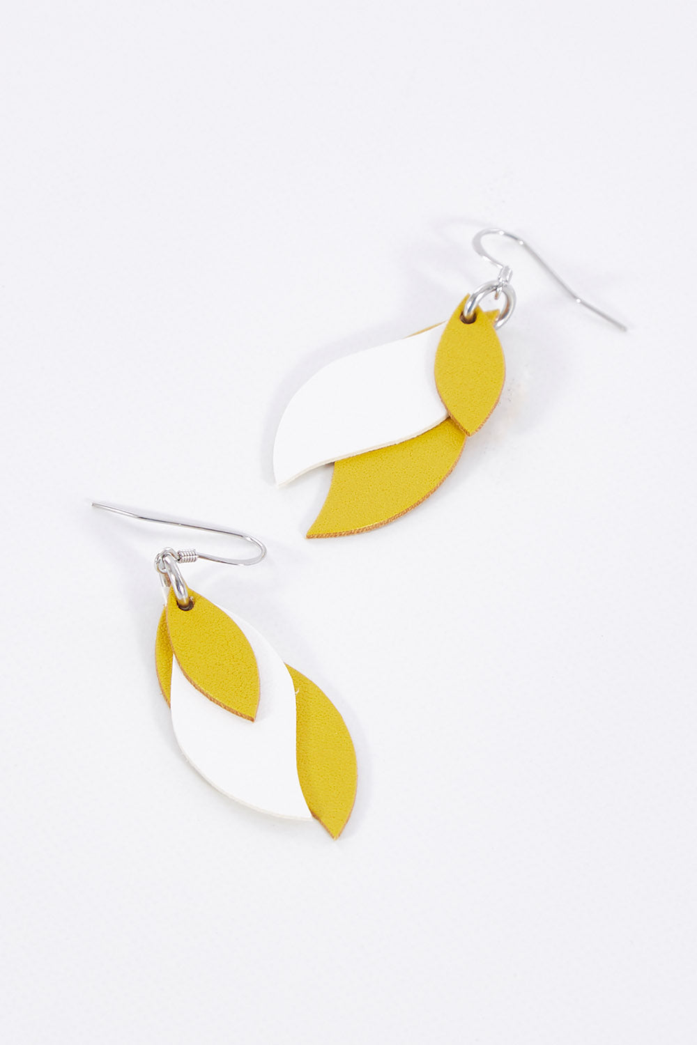 A model wearing size OneSize of the Australian Made Leather Leaf Earring in colour Yellowhite, from the front, showing the whole outfit