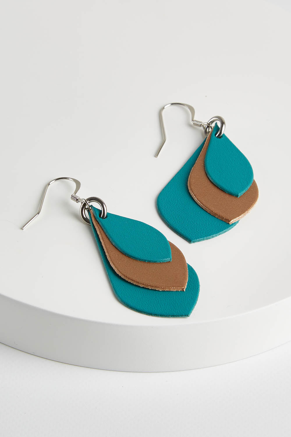 A model wearing size OneSize of the Australian Made Leather Teardrop Earring in colour Teal (Green), from the front, showing the whole outfit