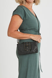 Model Sandy wearing size OneSize of the Femi Leather Crossbody in colour Black (Black), from the front, cropped image