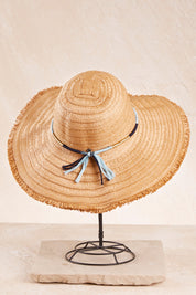 A model wearing size OneSize of the Kata Wide Brim Hat in colour Natural, from the front, showing the whole outfit