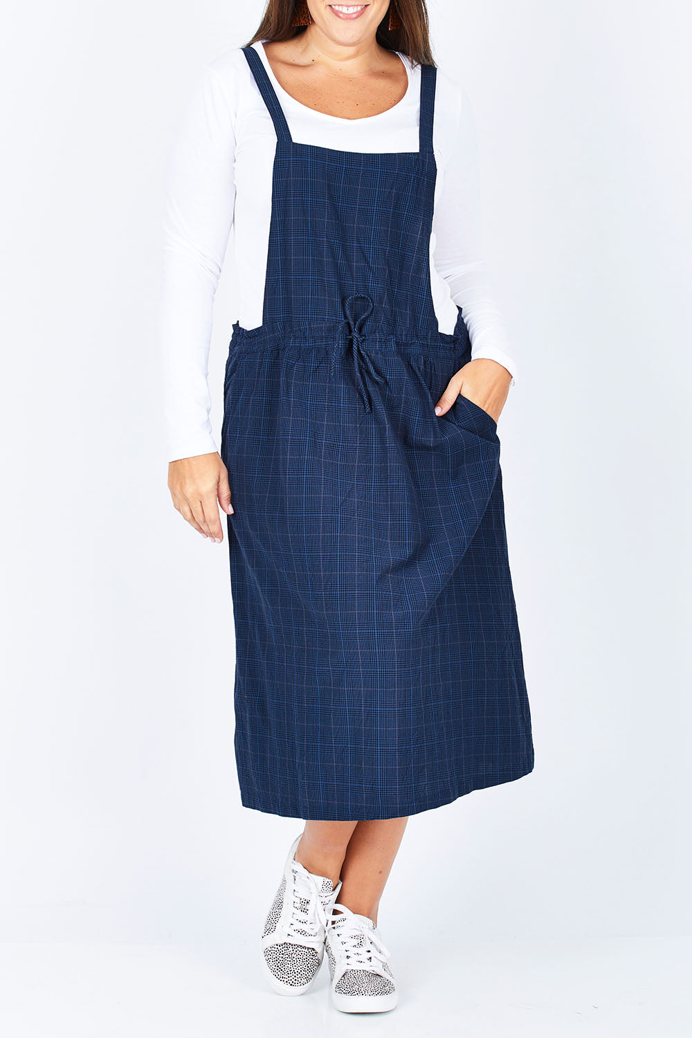 Model Stacey wearing size M of the Cara Pinafore in colour IndigoPlai (Blue), from the front, cropped image