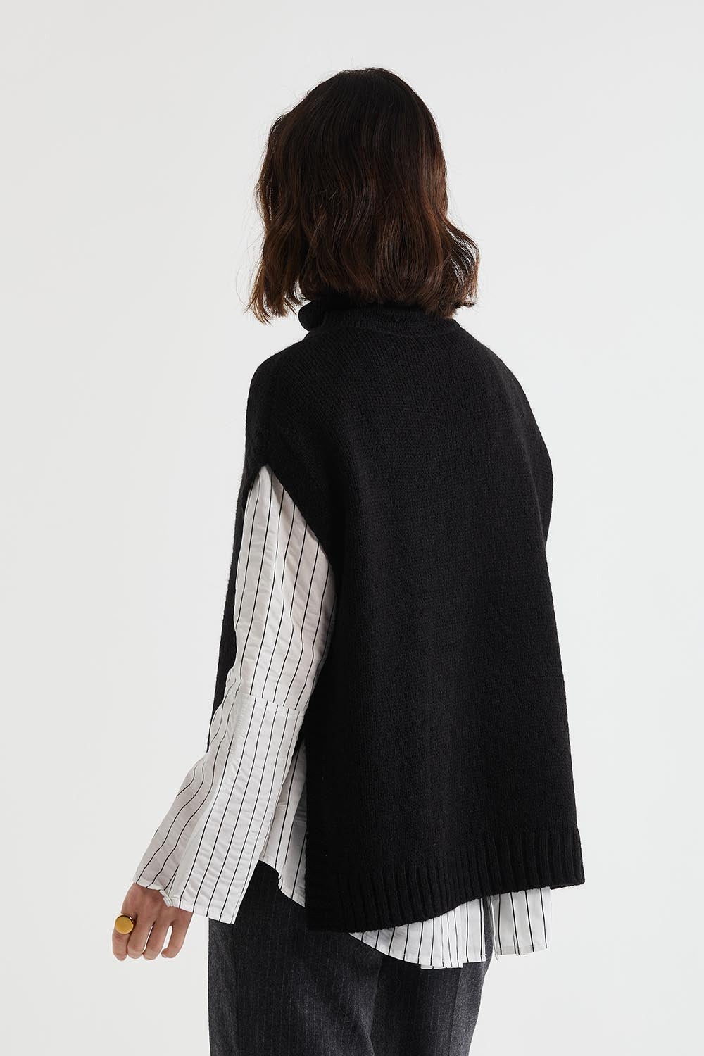 A model wearing the Lofty Tunic in colour Black (Black), from the back