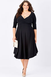 Model Mae wearing size 16 of the Stella Dress in colour Black (Black), from the front, showing the whole outfit
