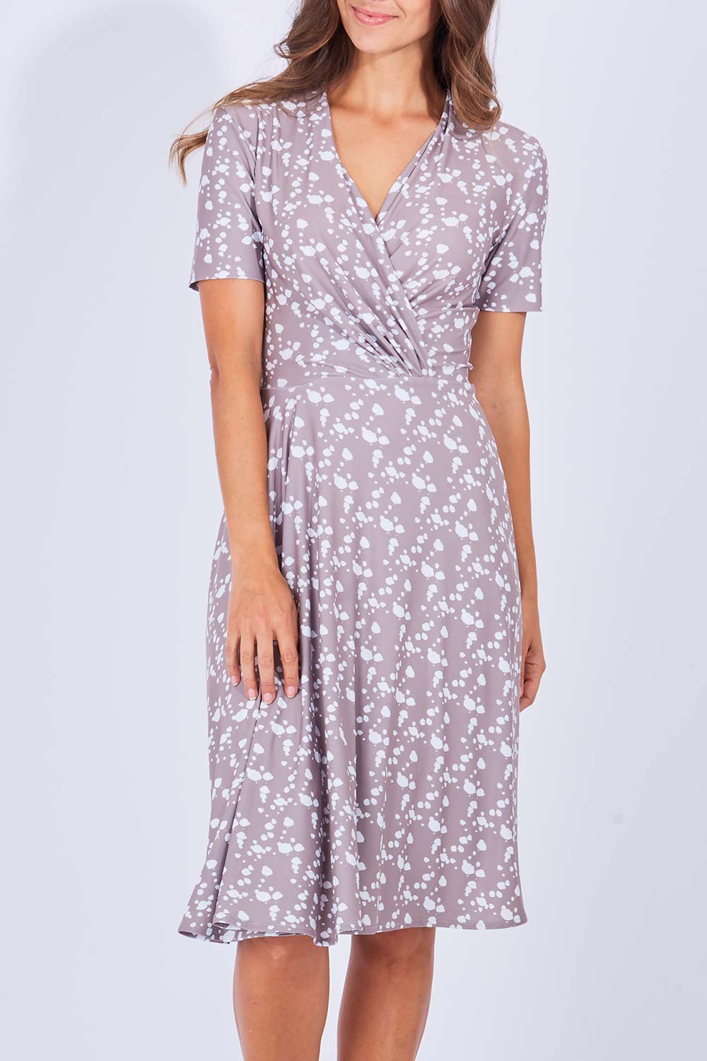 Model Anna wearing size 10 of the Flora Dress in colour Sand, from the front, cropped image