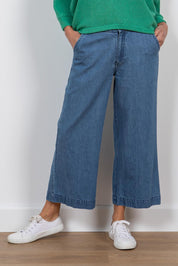A model wearing the Ruby Crop Jeans in colour Denim (Blue), from the front, cropped image