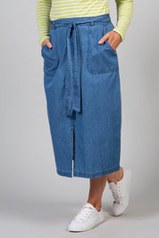 A model wearing the Cowslip Skirt in colour Denim (Blue), from the front, cropped image
