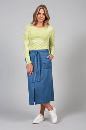 A model wearing the Cowslip Skirt in colour Denim (Blue), from the front, showing the whole outfit
