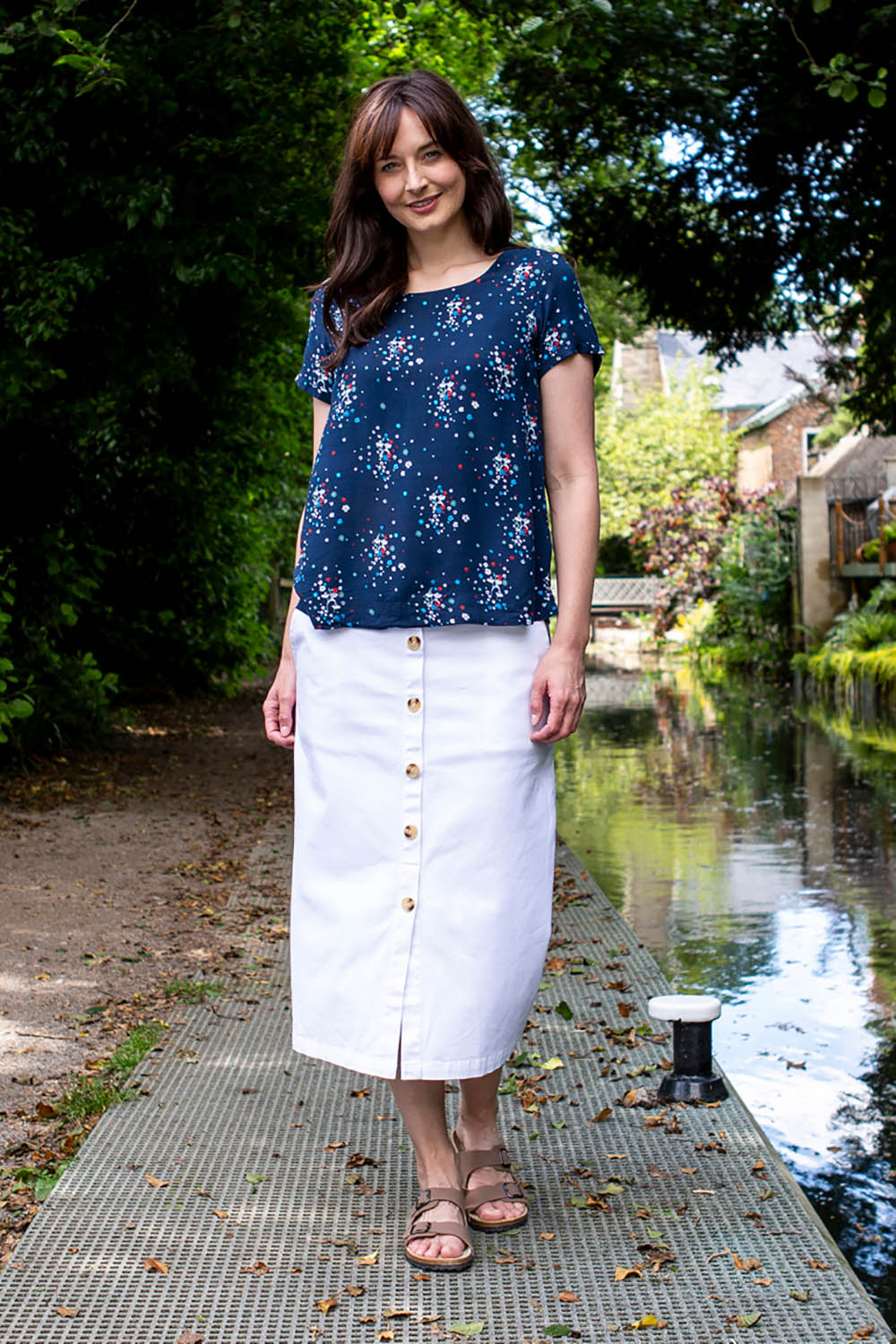A model wearing the Orchard Skirt in colour White (White), from the front, showing the whole outfit