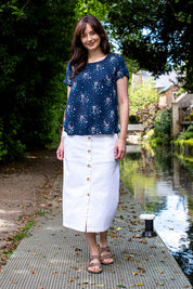 A model wearing the Orchard Skirt in colour White (White), from the front, showing the whole outfit