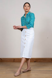 A model wearing the Orchard Skirt in colour White (White), from the front, showing the whole outfit
