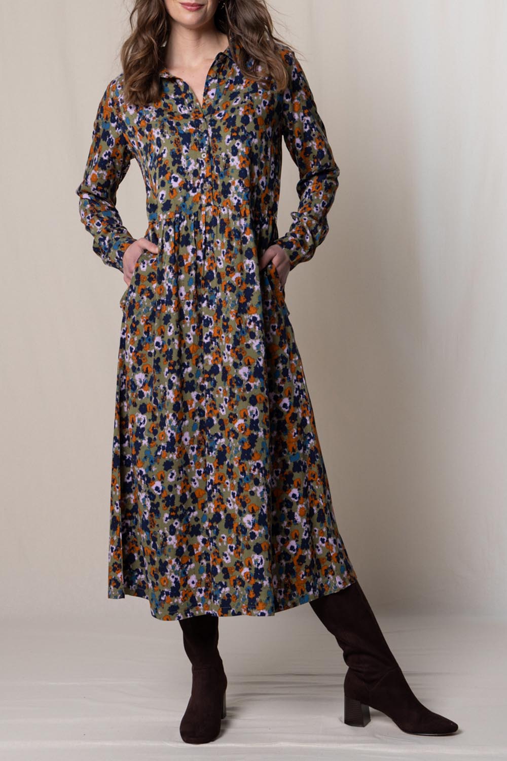 A model wearing the Seasons Dress in colour Olive (Green), from the front, cropped image