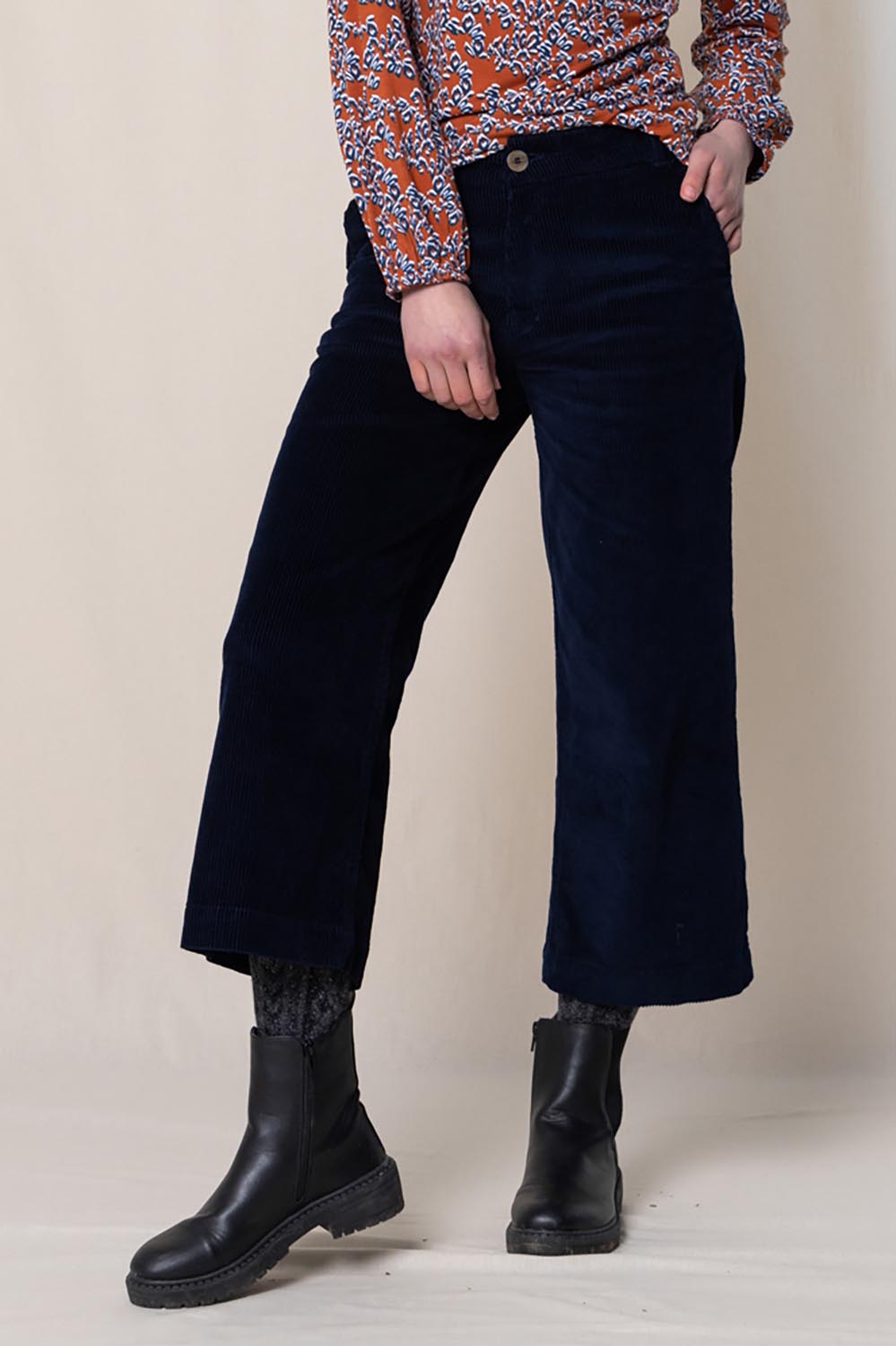 A model wearing the Isla Crop Cotton Cord Trouser in colour Navy (Blue), from the front, cropped image
