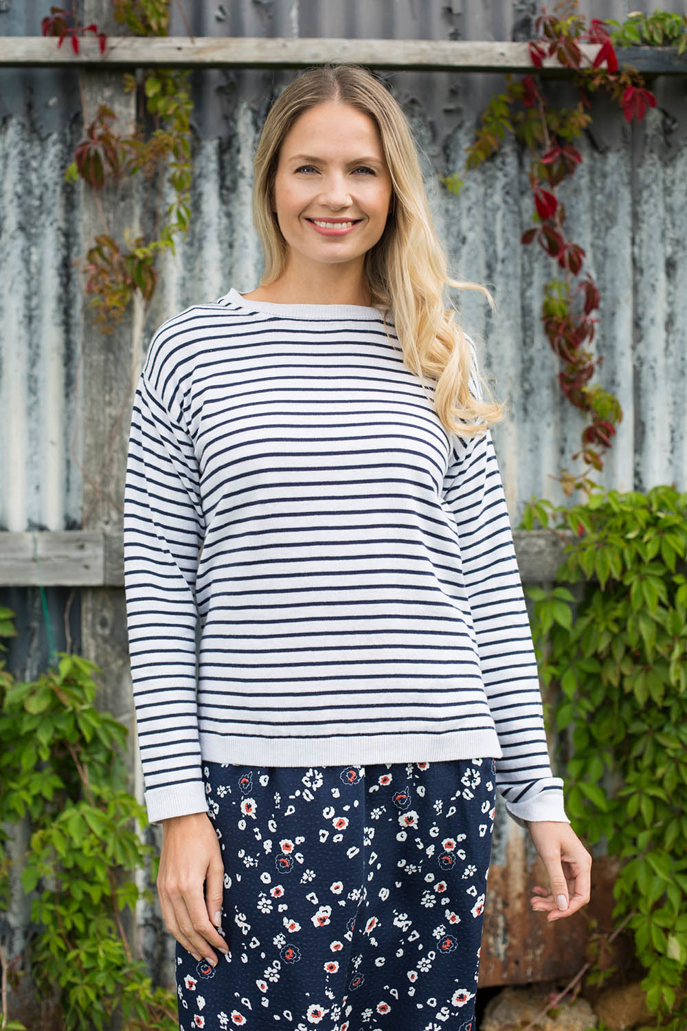 A model wearing the Meadow Stripe Jumper in colour Navystri (Blue), from the front, showing the whole outfit