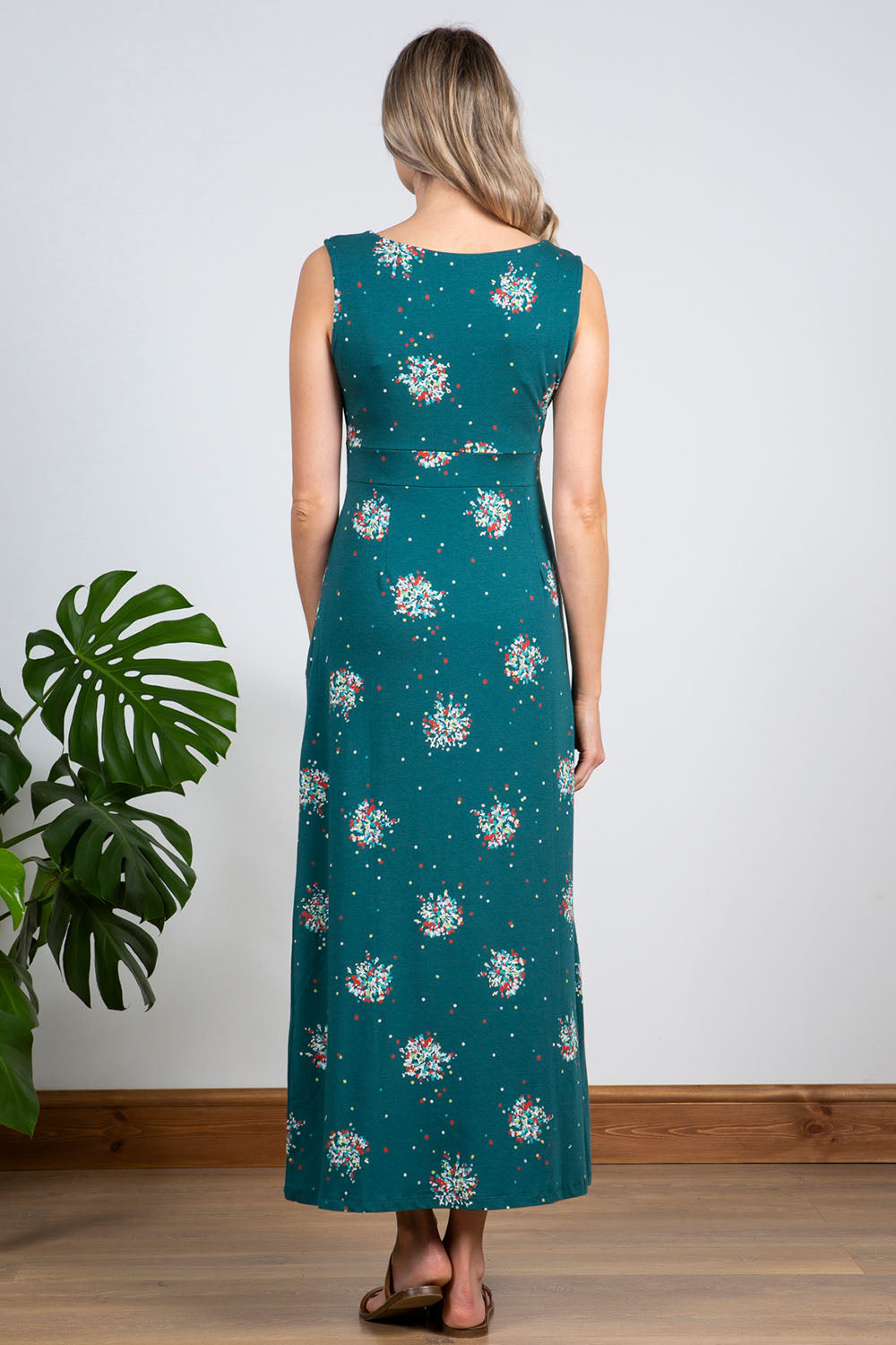 A model wearing the Chrissy Maxi Dress in colour Darkteal (Green), from the back