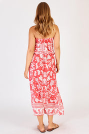 A model wearing the Agatha Strapless Dress in colour Melon (Red), from the back