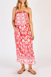 A model wearing the Agatha Strapless Dress in colour Melon (Red), from the front, cropped image