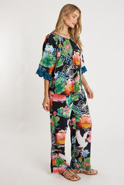 A model wearing the Akiko Pant in colour Ocean, from the front, showing the whole outfit