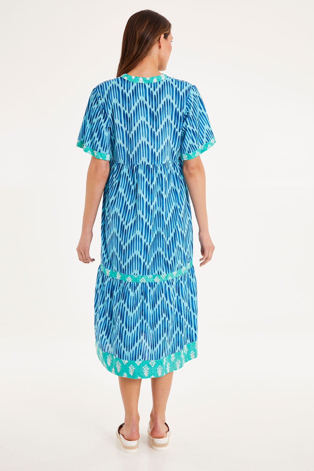 Model Madeline wearing size S of the Chevron Midi Dress in colour Ocean (Blue), from the back