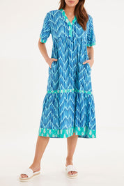 Model Madeline wearing size S of the Chevron Midi Dress in colour Ocean (Blue), from the front, cropped image