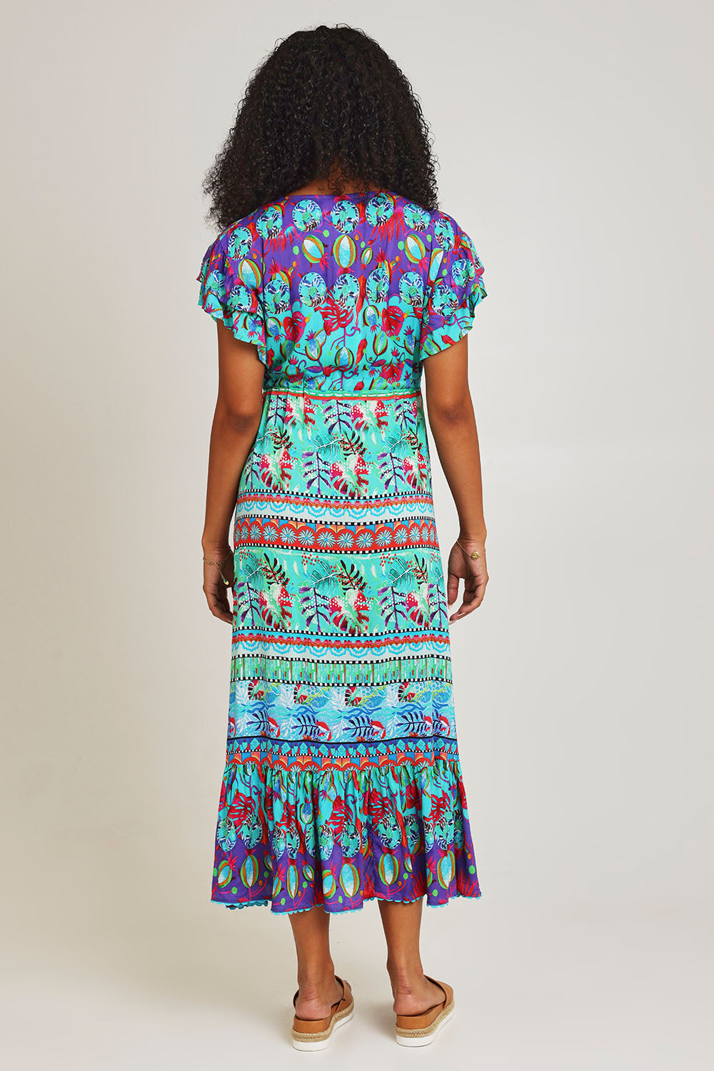 Model Ziara wearing size S of the Elisie Midi Dress in colour Sea (Blue), from the back
