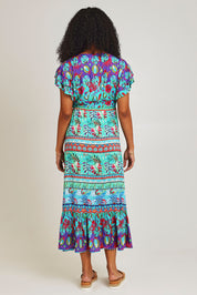 Model Ziara wearing size S of the Elisie Midi Dress in colour Sea (Blue), from the back
