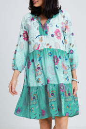 Model Andrea wearing size S of the Jerri Tiered Dress in colour Lagoon (Green), from the front, cropped image