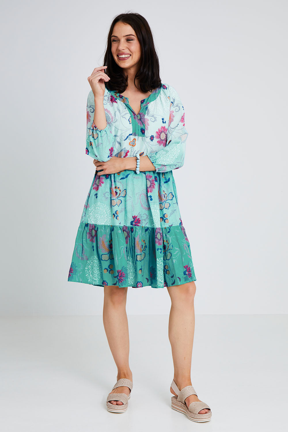 Model Andrea wearing size S of the Jerri Tiered Dress in colour Lagoon (Green), from the front, showing the whole outfit