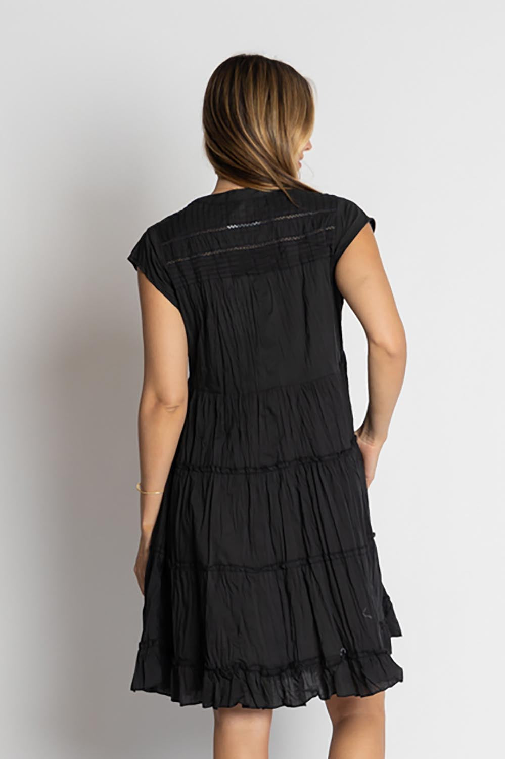 A model wearing the Shayna Cotton Tiered Dress in colour Black (Black), from the back