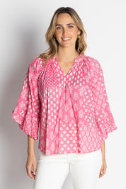 A model wearing the Talei Cotton Top in colour Musk (Pink), from the front, cropped image