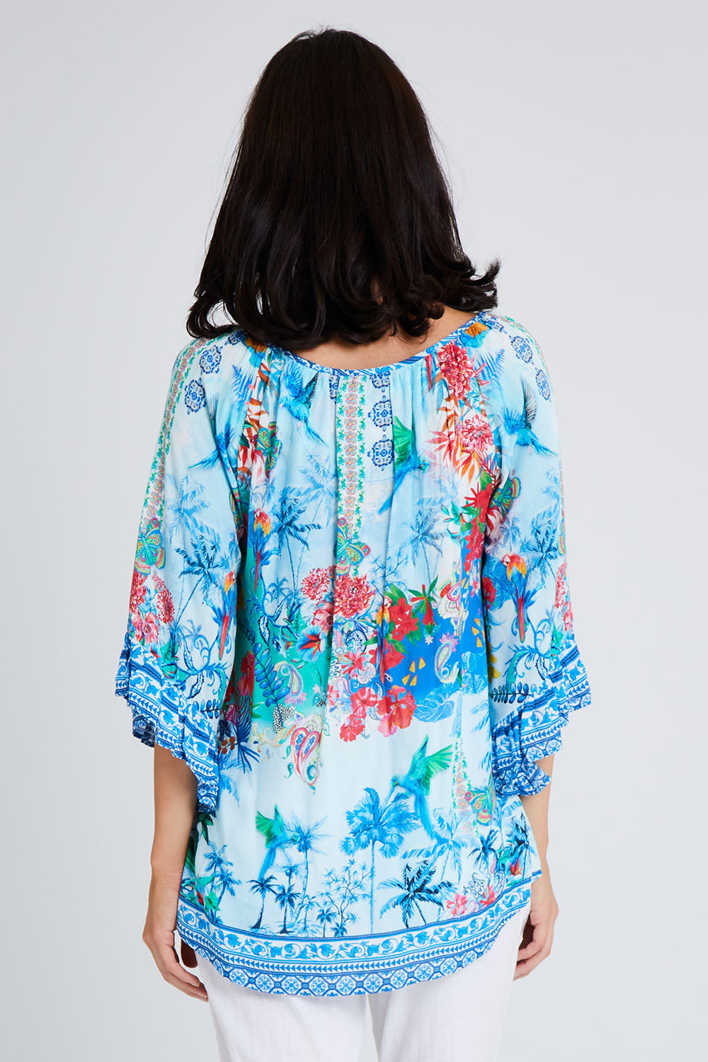 Model Andrea wearing size S of the Tara Top in colour Sky (Blue), from the back