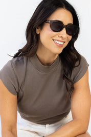 A model wearing the Faith Sunglasses in colour Black (Black), from the front, cropped image