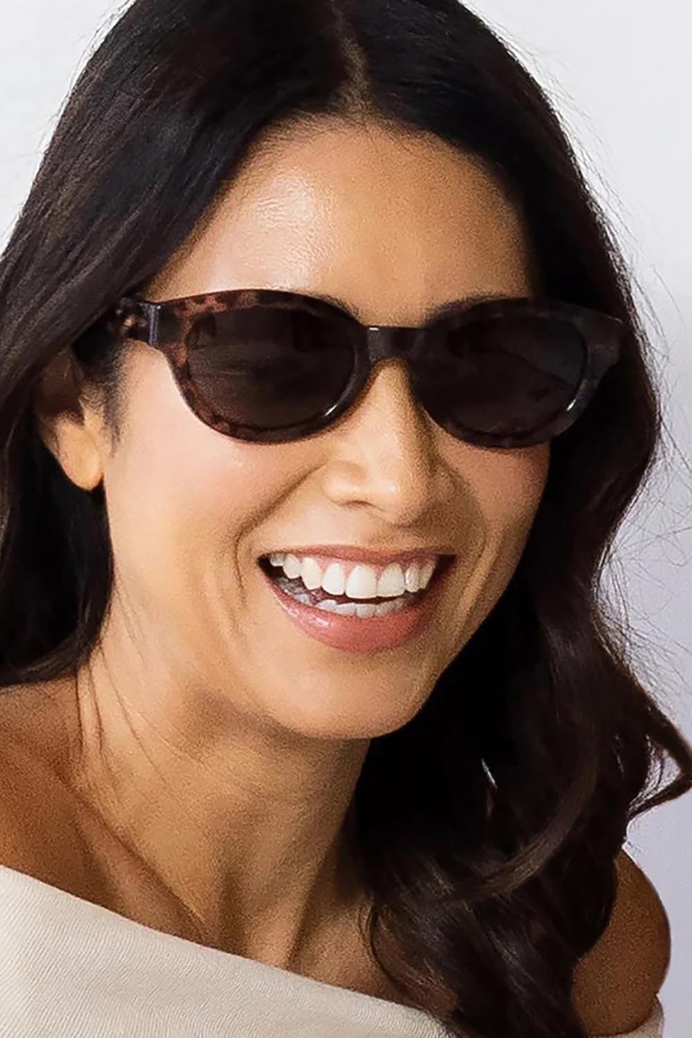 A model wearing the Faith Sunglasses in colour Shell, from the front, cropped image