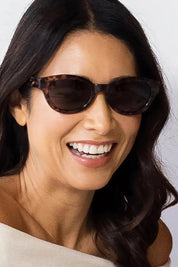 A model wearing the Faith Sunglasses in colour Shell, from the front, cropped image