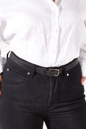 Model Charlotte wearing size S of the Cloe Vintage Leather Belt in colour Black (Black), from the front, cropped image