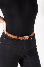 Model Charlotte wearing size XS of the Cloe Vintage Leather Belt in colour Nechestnut, from the front, cropped image
