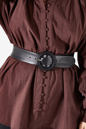 Model Charlotte wearing size S of the Skye Wide Leather Waist Belt in colour Black (Black), from the front, cropped image