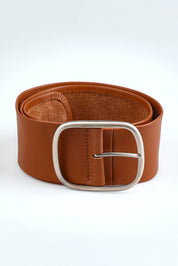 A model wearing size S of the Emma Wide Leather Belt in colour Cognac, from the front, showing the whole outfit