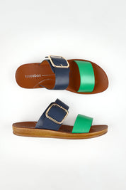 A model wearing size 37 of the Doti Double Strap Slide in colour Emeraldnav (Blue), from the front, showing the whole outfit