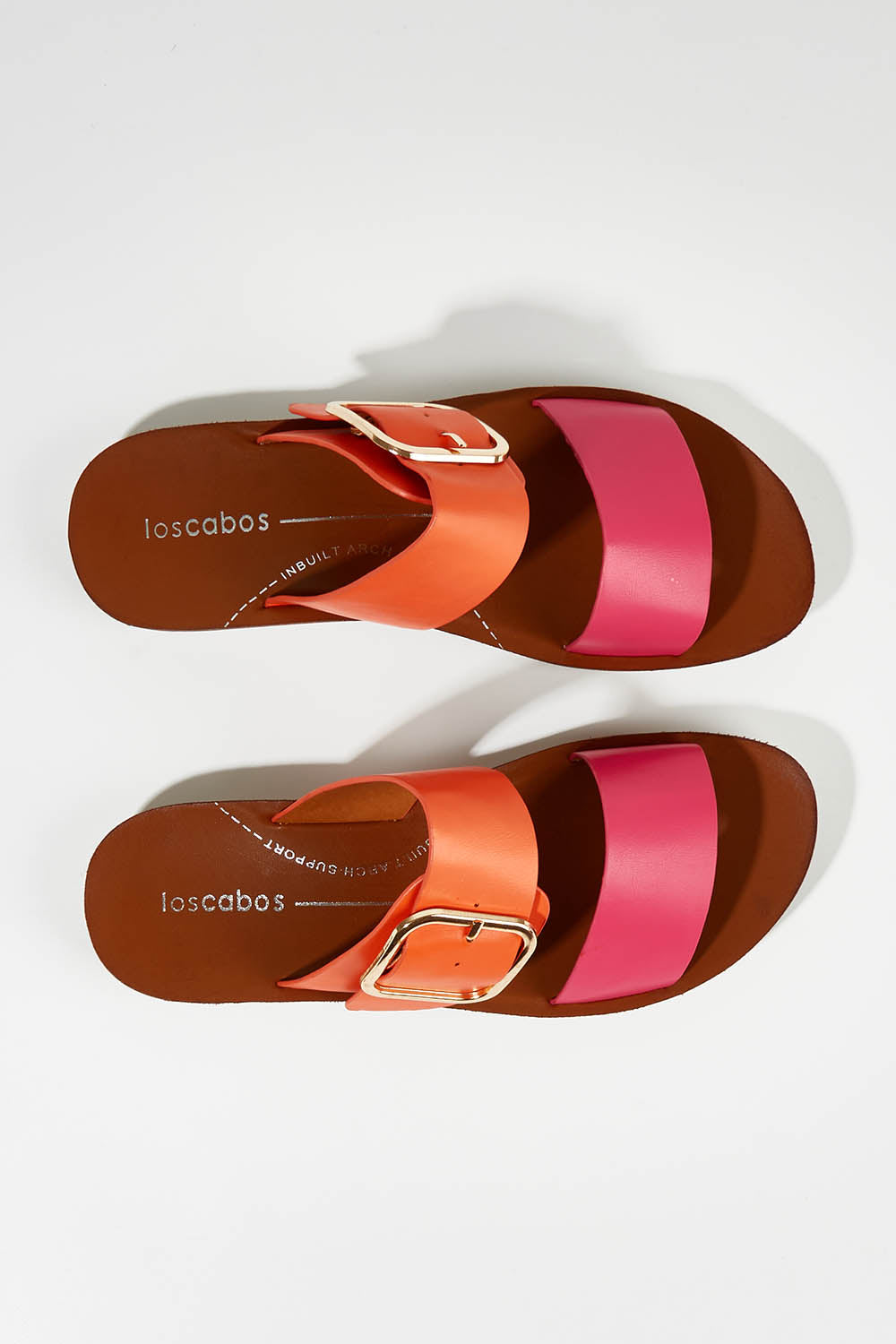 A model wearing size 37 of the Doti Double Strap Slide in colour Pinkorange (Pink), from the front, showing the whole outfit